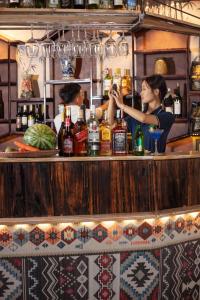 a woman making a drink at a bar at Gateway Inn PuLuong in Pu Luong