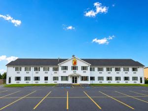 a large white building with a parking lot at Super 8 by Wyndham Canandaigua in Canandaigua