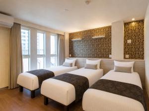 a hotel room with four beds and windows at Hotel SAILS in Tokyo +8 photos