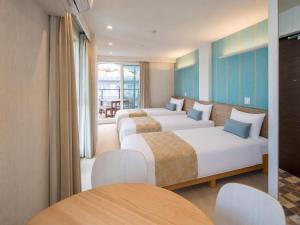 a hotel room with two beds and a table at Hotel SAILS in Tokyo