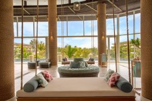 a living room with a couch and large windows at SOL by Meliá Phu Quoc in Phú Quốc