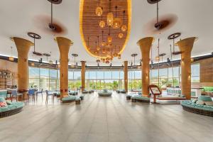 a large lobby with tables and chairs and a large chandelier at SOL by Meliá Phu Quoc in Phú Quốc