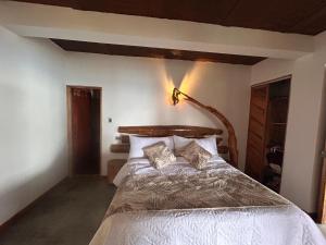 a bedroom with a large bed with white sheets and pillows at Las Trincheras del Café in Chaparral