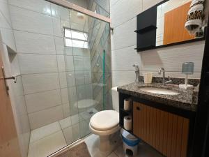 a bathroom with a shower and a toilet and a sink at Conforto - Casa completa com ar-cond - Wi-Fi in Trindade +38 photos