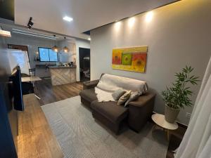 a living room with a couch and a kitchen at Conforto - Casa completa com ar-cond - Wi-Fi in Trindade