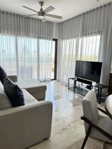 a living room with a couch and a flat screen tv at Navela oceanfront apartment in Telchac Puerto