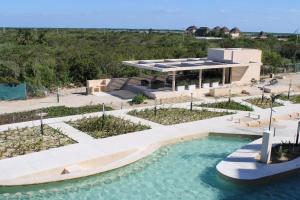 a house with a swimming pool in front of it at Navela oceanfront apartment in Telchac Puerto