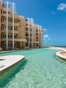 a view of the water in front of buildings at Navela oceanfront apartment in Telchac Puerto