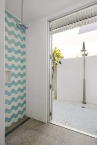 a door to a room with a cross on the wall at The Beach Shack: Getaway on Sunshine Beach in Noosa Heads