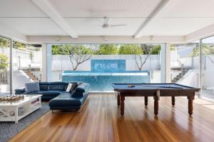 a living room with a pool table and a couch at The Beach Shack: Getaway on Sunshine Beach in Noosa Heads