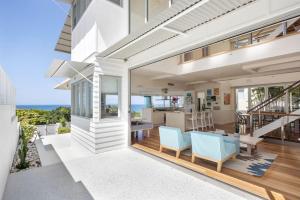 a white house with a dining room and a kitchen at The Beach Shack: Getaway on Sunshine Beach in Noosa Heads