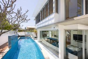 a swimming pool in front of a house at The Beach Shack: Getaway on Sunshine Beach in Noosa Heads