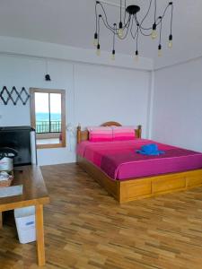 a bedroom with a bed and a desk and a television at Ban Rai Rabeang Mok in Khao Kho