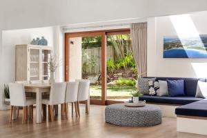 a living room with a table and a blue couch at Sunshine Beach Retreat, Pool, Backyard in Sunshine Beach