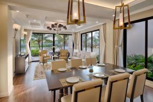 a dining room and living room with a table and chairs at Meliá Vinpearl Phu Quoc in Phú Quốc