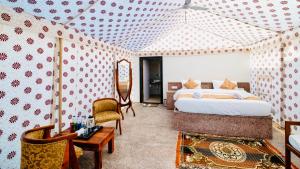 a bedroom with a bed and a table and chairs at Jaisalmer Sand Dunes Resort in Jaisalmer +43 photos