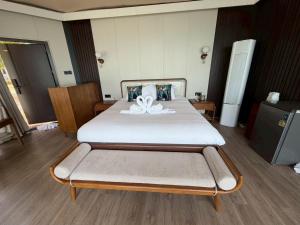 a bedroom with a large bed with white sheets at Umbrella tree V4 in Nathon +1 photo