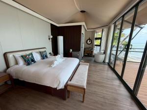 a bedroom with a large bed with a view of the ocean at Umbrella tree V4 in Nathon