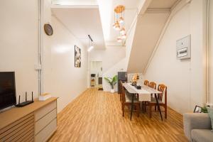 a living room with a table and a dining room at Siam Place - Spacious Family House in Bangkok in Bangkok