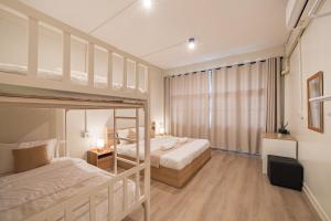 a bedroom with two bunk beds and a television at Siam Place - Spacious Family House in Bangkok in Bangkok