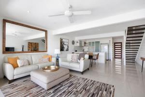 a living room with a couch and a table at Driftwood 6 Private Beach Stay in Noosaville