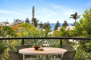 a table and chairs on a balcony with a view of the ocean at Beach Luxury, Ocean Views & Pool in Noosa Heads +11 photos