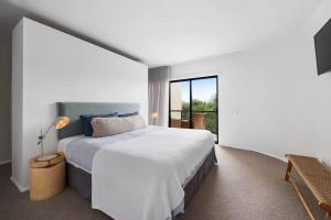 a bedroom with a large bed and a large window at Beach Luxury, Ocean Views & Pool in Noosa Heads