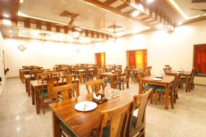 an empty restaurant with wooden tables and chairs at Jaisalmer Sand Dunes Resort in Jaisalmer