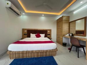 a bedroom with a bed and a desk and a bed sidx sidx sidx at Hotel Surya Inn in Kānsrao