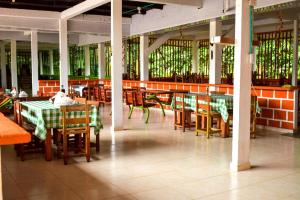a dining room with tables and chairs and stained glass windows at hotel con piscina Ladrilleros in Ladrilleros