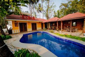 a house with a swimming pool in front of a house at Nina's Aqua - Private Pool Villa & Plunge Pool Studios, Anjuna in Anjuna