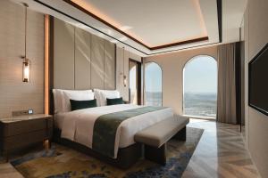 a bedroom with a large bed and a large window at Arjuna Solitaire Hotel in Sihanoukville +41 photos