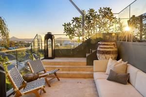 a living room with a couch and chairs on a balcony at Hastings Park: Lavish Ocean Vista Luxury in Noosa Heads