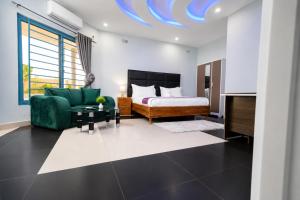 a bedroom with a bed and a green couch at NEBCON Executive Lodge in Kitwe