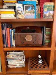 a book shelf with a radio and books at B&B Vernole1713 in Vernole