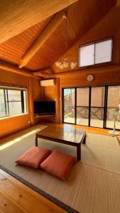 a living room with a table and some windows at Karin in Minami Aso