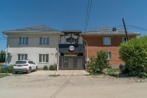 a house with a car parked in front of it at Ordo Hotel in Karakol