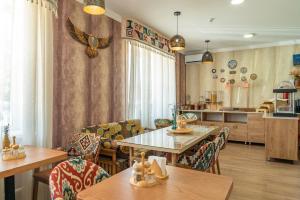 a dining room with tables and chairs and a kitchen at Ordo Hotel in Karakol