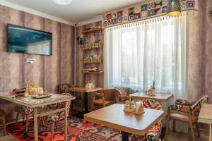 a restaurant with tables and chairs and a window at Ordo Hotel in Karakol