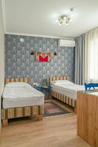 a bedroom with two beds and a sink at Ordo Hotel in Karakol