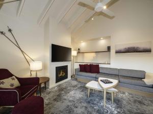 a living room with a couch and a fireplace at The Sebel Pinnacle Valley in Merrijig