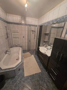 a bathroom with a tub and a sink at Ferienwohnung Tirolerhof in Horn +23 photos