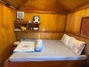 a bed in a room with a wooden wall at Que Nha Homestay in Ấp Chợ (2)