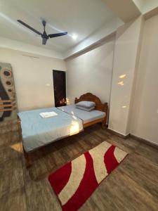 a bedroom with a bed and a red and white rug at Haven Stay in Panchanai