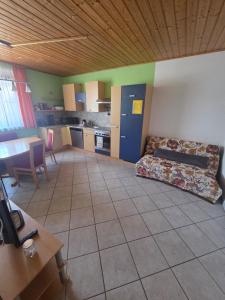 a living room with a couch and a table and a kitchen at Ferienwohnung Tirolerhof in Horn