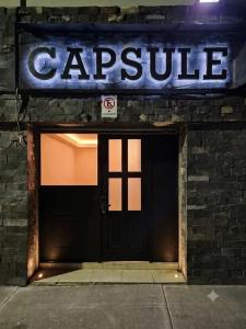 a garage door with a sign on a brick building at Capsule CDMX in Mexico City