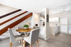 a kitchen and dining room with a wooden table and chairs at Moondarah: Pet-Friendly Escape in Noosa Heads