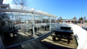 una casa de cristal con mesas y sillas en una terraza en Hotelli Marilyn en Harjavalta