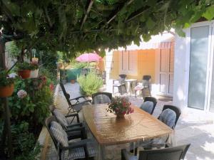 a wooden table and chairs in a patio with a table at Rooms Alida in Opatija