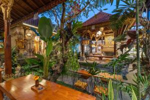 a restaurant with a wooden table and plants at Ubud Heritage Stay by Dhananjaya Hospitality in Ubud